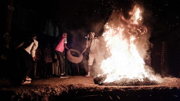 Men start burning tires on a broken bridge to celebrate the new year at the Kibera slum in Nairobi, Kenya. (Yasuyoshi CHIBA / AFP) Men start burning tires on a broken bridge to celebrate the new year at the Kibera slum in Nairobi, Kenya. (Yasuyoshi CHIBA / AFP)