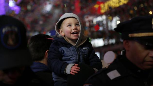 A young person watches confetti fall during a New Year's celebration in New York's Times Square, early Wednesday, Jan. 1, 2020. (AP Photo/Adam Hunger) (AP) 