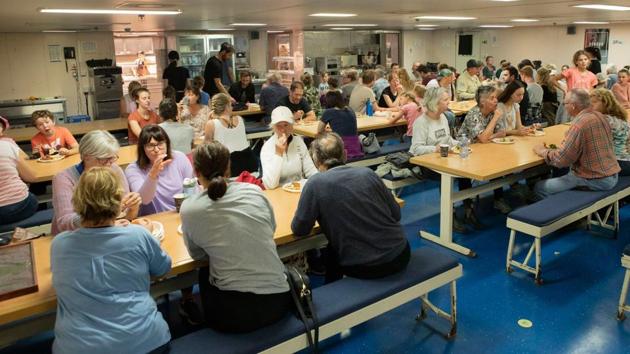 People seen eating after evacuated from Mallacoota, Victoria state, during bushfire relief efforts. Visitors are being warned to leave affected areas before Saturday, when another heatwave is expected to sweep across the country, with gusting winds and temperatures above 40 degrees Celsius (104 Fahrenheit). (Helen Franks/ROYAL AUSTRALIAN NAVY/AFP) People seen eating after evacuated from Mallacoota, Victoria state, during bushfire relief efforts. Visitors are being warned to leave affected areas before Saturday, when another heatwave is expected to sweep across the country, with gusting winds and temperatures above 40 degrees Celsius (104 Fahrenheit). (Helen Franks/ROYAL AUSTRALIAN NAVY/AFP)
