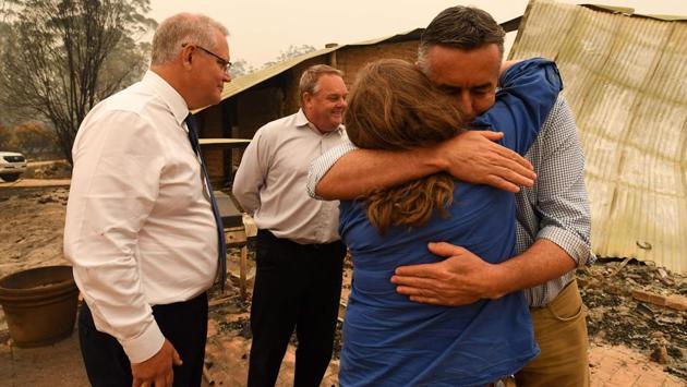 Australia's Prime Minister Scott Morrison (L) and MP Darren Chester (R) visit a wildflower farm in an area devastated by bushfires in Sarsfield, Victoria state. Scott Morrison has come under increasing pressure for his actions, which included holidaying in Hawaii as the disaster unfolded and reiterating his support for Australia’s lucrative -- but heavily polluting -- coal mining industry. (James Ross/POOL/AFP) Australia's Prime Minister Scott Morrison (L) and MP Darren Chester (R) visit a wildflower farm in an area devastated by bushfires in Sarsfield, Victoria state. Scott Morrison has come under increasing pressure for his actions, which included holidaying in Hawaii as the disaster unfolded and reiterating his support for Australia’s lucrative -- but heavily polluting -- coal mining industry. (James Ross/POOL/AFP)