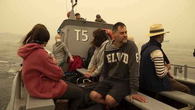 People being evacuated from Mallacoota, Victoria state on a landing craft to MV Sycamore, during bushfire relief efforts. Australia authorised the forced evacuation of residents on Thursday amid a mass exodus of tourists from fire-ravaged coastal communities, as the country braces for a weekend heatwave expected to fan deadly bushfires. (Shane Cameron/ROYAL AUSTRALIAN NAVY/AFP) People being evacuated from Mallacoota, Victoria state on a landing craft to MV Sycamore, during bushfire relief efforts. Australia authorised the forced evacuation of residents on Thursday amid a mass exodus of tourists from fire-ravaged coastal communities, as the country braces for a weekend heatwave expected to fan deadly bushfires. (Shane Cameron/ROYAL AUSTRALIAN NAVY/AFP)