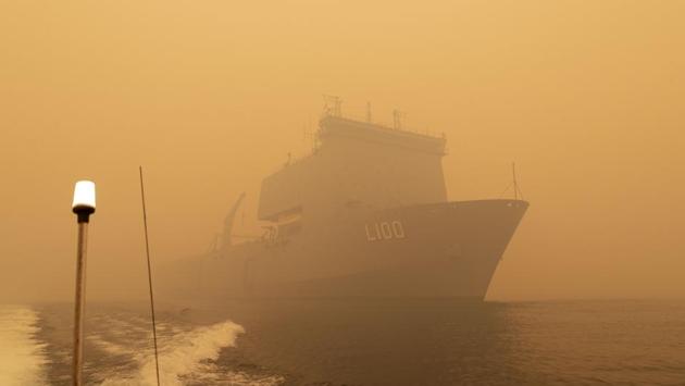 HMAS Choules sailing off the coast of Mallacoota, Victoria state to assist in bushfire relief efforts. Two Navy ships arrived in Mallacoota -- where people huddled on the foreshore for hours on New Year’s Eve as a fire bore down on the remote town -- to begin evacuating up to 4,000 people in an operation officials say could take weeks. (Helen Frank/ROYAL AUSTRALIAN NAVY/AFP) HMAS Choules sailing off the coast of Mallacoota, Victoria state to assist in bushfire relief efforts. Two Navy ships arrived in Mallacoota -- where people huddled on the foreshore for hours on New Year’s Eve as a fire bore down on the remote town -- to begin evacuating up to 4,000 people in an operation officials say could take weeks. (Helen Frank/ROYAL AUSTRALIAN NAVY/AFP)