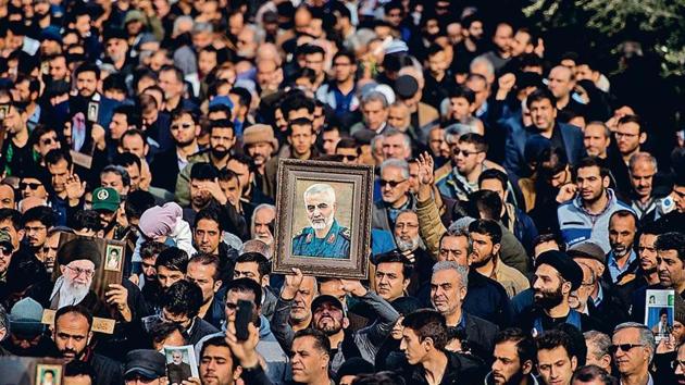 Protesters hold up a photograph of Qassem Soleimani in Tehran, Iran, on Friday. (Bloomberg) Protesters hold up a photograph of Qassem Soleimani in Tehran, Iran, on Friday. (Bloomberg)
