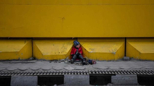 A young shoe-shiner sits as he waits for customers alongside a street in Kabul, Afghanistan. (Farshad Usyan / AFP) A young shoe-shiner sits as he waits for customers alongside a street in Kabul, Afghanistan. (Farshad Usyan / AFP)