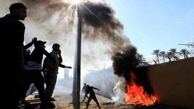 Hashd al-Shaabi (paramilitary forces) fighters set fire on the US Embassy wall to condemn air strikes on their bases, in Baghdad, Iraq. (Thaier al-Sudani / REUTERS) Hashd al-Shaabi (paramilitary forces) fighters set fire on the US Embassy wall to condemn air strikes on their bases, in Baghdad, Iraq. (Thaier al-Sudani / REUTERS)