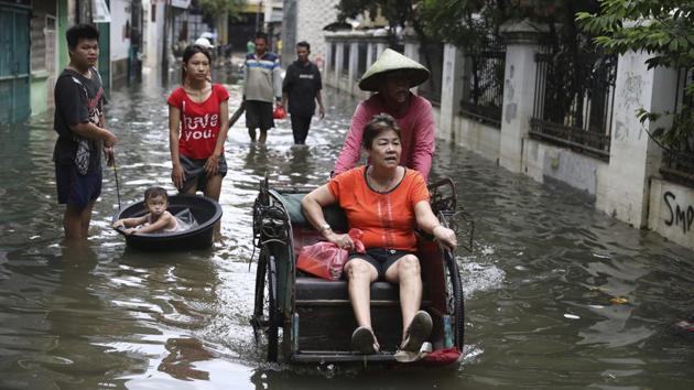 A woman rides a tricycle on a flooded street in Jakarta. Around a dozen people are still unaccounted for after record rains that started on New Year’s Eve pounded the capital and left swathes of the megalopolis -- home to some 30 million -- underwater and thousands homeless. (Dita Alangkara / AP) A woman rides a tricycle on a flooded street in Jakarta. Around a dozen people are still unaccounted for after record rains that started on New Year’s Eve pounded the capital and left swathes of the megalopolis -- home to some 30 million -- underwater and thousands homeless. (Dita Alangkara / AP)