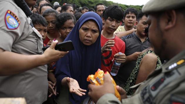 People queue up to receive food at an aid distribution point for those affected by the floods in Jakarta, Indonesia, Saturday, Jan. 4, 2020. Monsoon rains and rising rivers submerged parts of greater Jakarta and caused landslides in Bogor and Depok districts on the city's outskirts as well as in neighbouring Lebak, which buried a number of people. (Dita Alangkara / AP) People queue up to receive food at an aid distribution point for those affected by the floods in Jakarta, Indonesia, Saturday, Jan. 4, 2020. Monsoon rains and rising rivers submerged parts of greater Jakarta and caused landslides in Bogor and Depok districts on the city's outskirts as well as in neighbouring Lebak, which buried a number of people. (Dita Alangkara / AP)