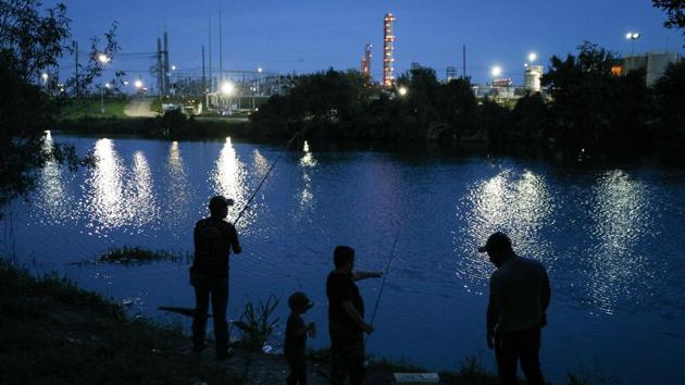 Local residents fish in a bayou across from an industrial plant. Doctors have found four lumps in Barragan’s lungs and now more growths, according to the medical records he showed Reuters. The first ones were not cancerous. Barragan says he has not been able to afford imaging of the new growths. He hopes they are benign so he can watch his children grow up. (Loren Elliott / REUTERS)