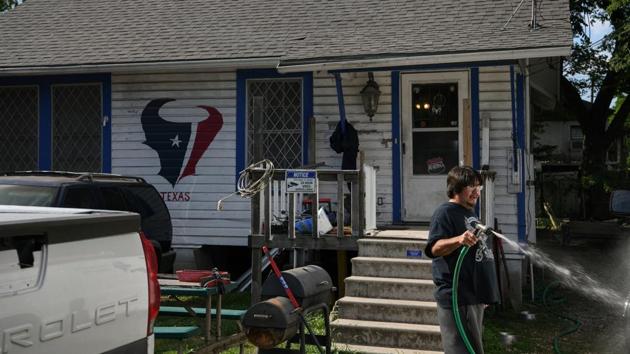 Eugene Barragan washes his van in his yard. Residents claim that the pollution is taking a toll on their health, although the scientific evidence does not prove that. “I want to get out of here and go to the country and find some cleaner air,” Barragan, a 56-year-old electrician who has lived most of his life by the refineries told Reuters. “It would be better for me and the kids.” (Loren Elliott / REUTERS)