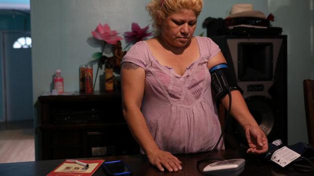 Dennys Nieto does routine health checks on herself at home. She checks her blood pressure and listens to her heart beat regularly. “In the air I feel it’s this we’re all breathing. This is why I want to leave from here,” Nieto said. “I want to go somewhere that is far from the refineries so that I can repair my life, repair my health and live better.” (Loren Elliott / REUTERS)