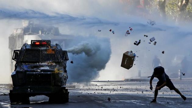 A demonstrator throws items at an armoured vehicle during a protest against Chile’s government in Santiago, Chile. (Ivan Alvarado / REUTERS) A demonstrator throws items at an armoured vehicle during a protest against Chile’s government in Santiago, Chile. (Ivan Alvarado / REUTERS)