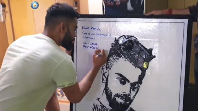 Virat Kohli signs his portrait.(Screengrab/BCCI)