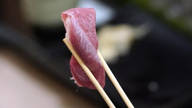 A customer holds a piece of tuna sushi with a pair of chopsticks at a Sushizanmai restaurant, operated by Kiyomura Corp., in Tokyo, Japan, on Sunday, Jan. 5, 2020. A bluefin tuna weighing a staggering 276 kilograms (608 pounds) was sold for 193.2 million yen ($1.79 million) on Sunday at a Tokyo fish market, the second-highest price on record. (Bloomberg) A customer holds a piece of tuna sushi with a pair of chopsticks at a Sushizanmai restaurant, operated by Kiyomura Corp., in Tokyo, Japan, on Sunday, Jan. 5, 2020. A bluefin tuna weighing a staggering 276 kilograms (608 pounds) was sold for 193.2 million yen ($1.79 million) on Sunday at a Tokyo fish market, the second-highest price on record. (Bloomberg)
