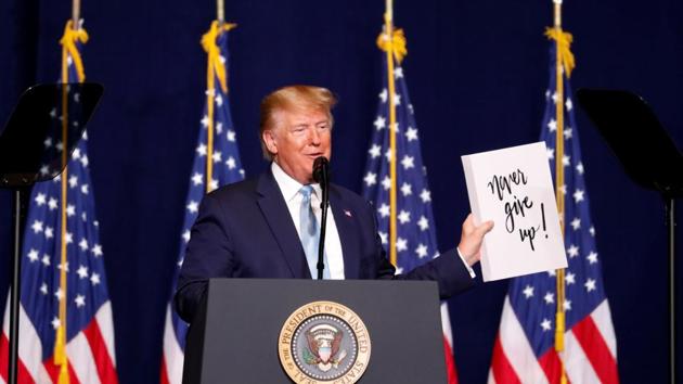 U.S. President Donald Trump holds a sign depicting 'Never give up!' as he gives his speech to evangelical supporters in Miami, Florida, U.S. (REUTERS) U.S. President Donald Trump holds a sign depicting 'Never give up!' as he gives his speech to evangelical supporters in Miami, Florida, U.S. (REUTERS)