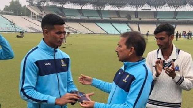 Ritwik Roy Chowdhury receives his cap from Bengal Ranji team coach Arun Lal at Eden Gardens.(Twitter/CAB)