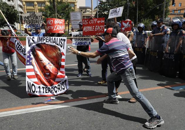 Protesters throw eggs filled with paint on the image of U.S. President Donald Trump as they hold a rally opposing the recent U.S. attacks.(Photo : AP)
