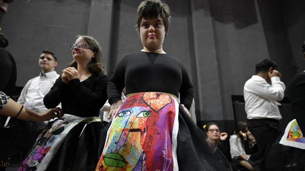A child with Down syndrome in a skirt displaying drawings at the “heART Couture” show. “The two shows were their chance to shine, to feel important and talented, to feel they bring a contribution to the world we live in,” Georgeta Bucur, who leads the Down Plus Association which promotes the inclusion in Romanian society of people with Down syndrome, told AP. (Andreea Alexandru/AP) A child with Down syndrome in a skirt displaying drawings at the “heART Couture” show. “The two shows were their chance to shine, to feel important and talented, to feel they bring a contribution to the world we live in,” Georgeta Bucur, who leads the Down Plus Association which promotes the inclusion in Romanian society of people with Down syndrome, told AP. (Andreea Alexandru/AP)