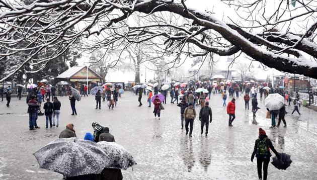 Tourists and locals hold umbrellas as they flock to the Ridge during the first snowfall of the year 2020, in Shimla, Himachal Pradesh, India, on Saturday, January 4, 2020.(Photo: Deepak Sansta / Hindustan Times)