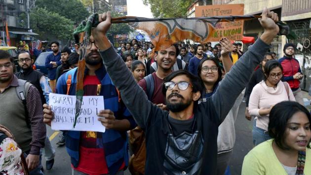 Students of Kolkata’s Jadavpur University tear-off a BJP flag during a protest on Monday against the attack on students of Jawaharlal Nehru University.(ANI)
