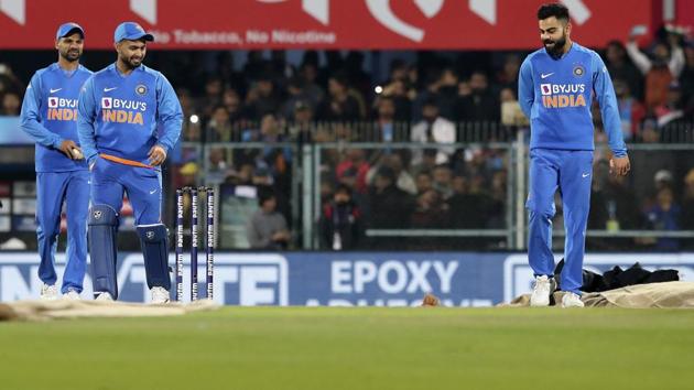 Virat Kohli, right, with his teammates come to inspect the pitch after the rain during the first T20I. (AP) Virat Kohli, right, with his teammates come to inspect the pitch after the rain during the first T20I. (AP)
