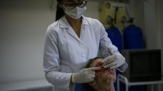 Vicentin’s transformation began in 2018. Dib implanted titanium rods in her eye socket to hold the prosthesis. Over the next year, she underwent surgeries to build up her facial tissue. Using a smartphone, Salazar took 15 pictures of her face from different angles, which were used to make a 3D digital model. Using that model, a graphic designer created a mirror image of the healthy half of Vicentin’s face. (Miguel Schincariol/AFP) Vicentin’s transformation began in 2018. Dib implanted titanium rods in her eye socket to hold the prosthesis. Over the next year, she underwent surgeries to build up her facial tissue. Using a smartphone, Salazar took 15 pictures of her face from different angles, which were used to make a 3D digital model. Using that model, a graphic designer created a mirror image of the healthy half of Vicentin’s face. (Miguel Schincariol/AFP)