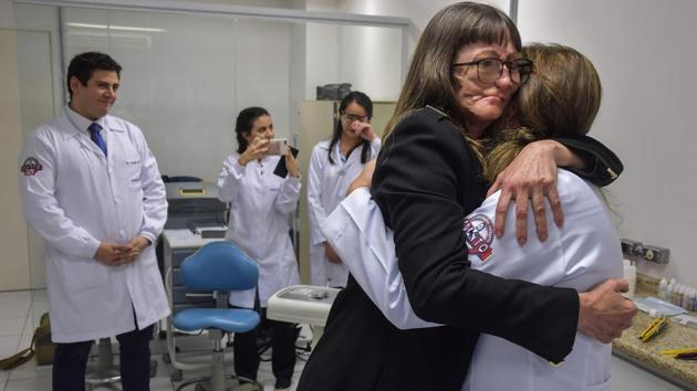 Denise Vicentin embraces a member of Doctor Salazar’s (L) medical staff. For Vicentin, the journey is not over. She needs further treatment to restore her jaw and top lip. But for now, she is overjoyed. “It was a long time looking at a face which was missing a piece, so I am so happy,” she told AFP after spending her first night at home with the prosthesis. “I only took it off to clean it—I even slept with it.” (Nelson Almeida/AFP) Denise Vicentin embraces a member of Doctor Salazar’s (L) medical staff. For Vicentin, the journey is not over. She needs further treatment to restore her jaw and top lip. But for now, she is overjoyed. “It was a long time looking at a face which was missing a piece, so I am so happy,” she told AFP after spending her first night at home with the prosthesis. “I only took it off to clean it—I even slept with it.” (Nelson Almeida/AFP)