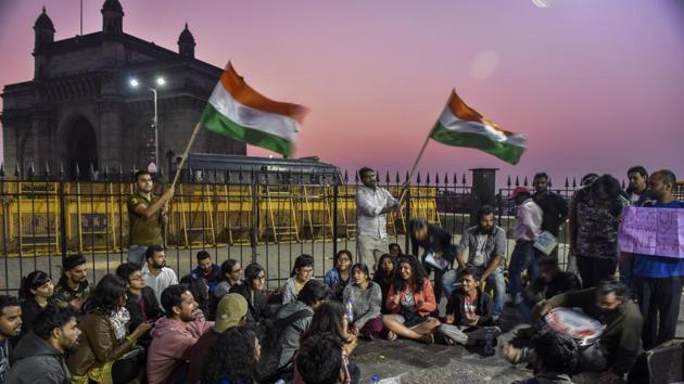 People wave the national flag early on Monday. A group of approximately 50 doctors joined the protest at Gateway. Developmental paediatrician Samir Dalwai said, “What happened on Sunday was a planned attack on students. This cannot be accepted.” (Anshuman Poyrekar / HT Photo) People wave the national flag early on Monday. A group of approximately 50 doctors joined the protest at Gateway. Developmental paediatrician Samir Dalwai said, “What happened on Sunday was a planned attack on students. This cannot be accepted.” (Anshuman Poyrekar / HT Photo)