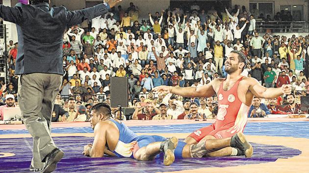 The 63rd Maharashtra Kesari final saw Harshvardhan Sadgir (red) and Shailesh Shelke, both belonging to Kaka Pawar Talim and under coach Kaka Pawar, face each other. Sadgir bagged the title at the event held at Shiv Chhatrapati sports complex in Balewadi on Tuesday.(MILIND SAURKAR/HT)
