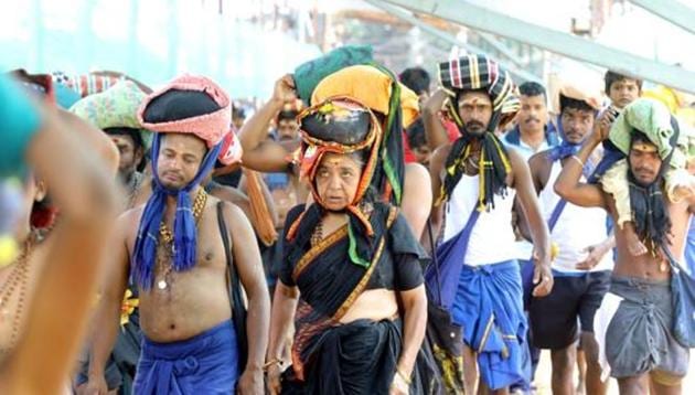 A woman is seen among the crowd of devotees at the Pamba base camp of Sabarimala Temple as the shrine opened for Mandala-Makaravilakku pooja in the evening, at Pathanamthitta district of Kerala, India, on Saturday, November 16, 2019.(Vivek R Nair / Hindustan Times)