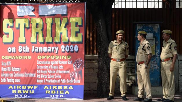Police stand beside a poster board announcing the strike, outside the Reserve Bank of India in Hyderabad. Six bank unions are supporting the Bharat Bandh. All India Bank Employees Association general secretary C H Venkatachalam told PTI that the government’s moves such as merger of PSUs, bank mergers and privatisation have led them to join the strike. (Noah Seelam / AFP)