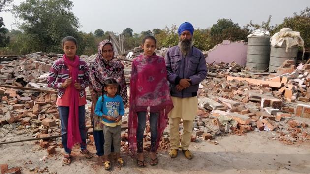 Surendra Singh with his wife and three daughters amid the debris of their house that was demolished by the administration in the tribal-dominated Karahal tehsil of Sheopur district on the Madhya Pradesh-Rajasthan border in December-end.(HT Photo)