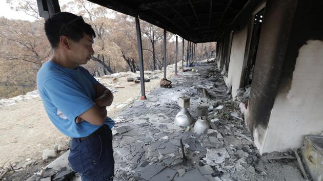 Justin Kam surveys his home. A long struggle lies ahead. The family is finding it difficult to navigate through all the red tape, and they didn’t have insurance on their house. Justin, a woodworker who built all the family’s furniture, said that was because they had other financial priorities, such as school fees and looking after aging relatives. (Rick Rycroft / AP) Justin Kam surveys his home. A long struggle lies ahead. The family is finding it difficult to navigate through all the red tape, and they didn’t have insurance on their house. Justin, a woodworker who built all the family’s furniture, said that was because they had other financial priorities, such as school fees and looking after aging relatives. (Rick Rycroft / AP)
