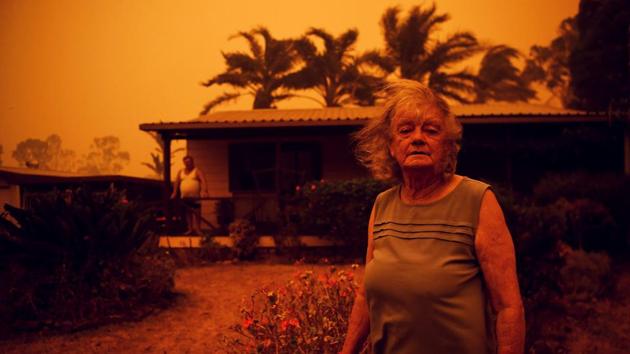 Nancy Allen and Brian Allen (behind) stand outside the house as high winds push smoke and ash from the Currowan Fire towards Nowra, New South Wales, Australia. (Tracey Nearmy / REUTERS) Nancy Allen and Brian Allen (behind) stand outside the house as high winds push smoke and ash from the Currowan Fire towards Nowra, New South Wales, Australia. (Tracey Nearmy / REUTERS)