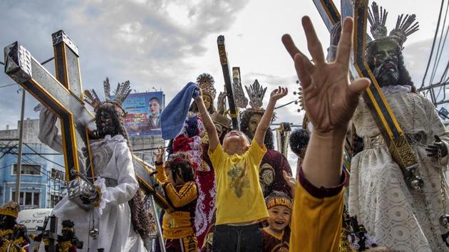 Children aboard a float carrying replicas of the Black Nazarene jubilate as they are doused with holy water, during a parade ahead of the Feast of the Black Nazarene in Manila, Philippines. The Black Nazarene is a dark wood sculpture of Jesus brought to the Philippines in 1606 from Spain and considered sacred by Filipino devotees. (Ezra Acayan / Getty Images) Children aboard a float carrying replicas of the Black Nazarene jubilate as they are doused with holy water, during a parade ahead of the Feast of the Black Nazarene in Manila, Philippines. The Black Nazarene is a dark wood sculpture of Jesus brought to the Philippines in 1606 from Spain and considered sacred by Filipino devotees. (Ezra Acayan / Getty Images)