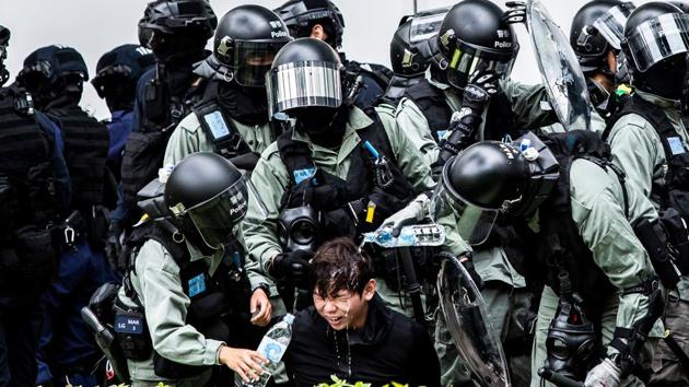 A man (C) has pepper spray washed off his face by the police after being detained during a clearance operation after a demonstration against parallel trading in Sheung Shui in Hong Kong on January 5, 2020. In recent years, Sheung Shui has been swamped by a huge influx of mainlanders and parallel traders seeking to circumvent Chinese taxes, angering many residents who have seen their local shops transformed to cater to visitors. (Isaac Lawrence / AFP) A man (C) has pepper spray washed off his face by the police after being detained during a clearance operation after a demonstration against parallel trading in Sheung Shui in Hong Kong on January 5, 2020. In recent years, Sheung Shui has been swamped by a huge influx of mainlanders and parallel traders seeking to circumvent Chinese taxes, angering many residents who have seen their local shops transformed to cater to visitors. (Isaac Lawrence / AFP)