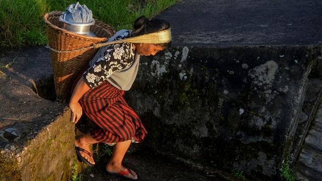 A woman carries a bucket after collecting drinking water from a stream. Last July, nearly a thousand people were killed as floods swept through the eastern Indian states of Bihar, West Bengal and Assam, as well as in neighbouring Nepal and Bangladesh. At the same time large swathes of southern and western India faced severe drought. Chennai officials declared it had reached ‘Day Zero’ as the taps ran dry. The locals had to then rely on water tankers. (Diptendu Dutta / AFP)