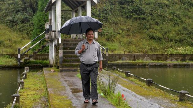Village head Tarcisius Dkhar walks near a water harvesting pond and drainage retaining wall at Nongthymmai-Lumthangding village. “Since the villagers play a role in building and maintaining these reservoirs, they feel a sense of ownership. They use water more responsibly,” he said. (Diptendu Dutta / AFP)