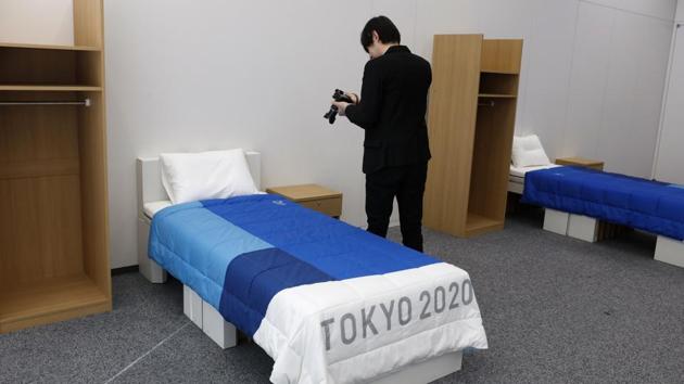A journalist films a cardboard bed in a display room showing furniture for the Tokyo 2020 Olympic and Paralympic Villages.(AP)