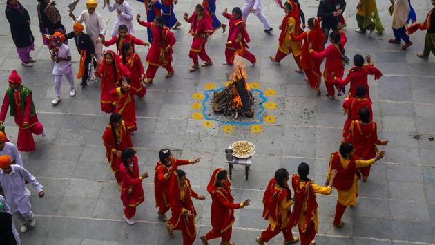 Jammu: Students in traditional attire dance around a bonfire as they celebrate Lohri festival in Jammu, Saturday, Jan. 11, 2020.(PTI)
