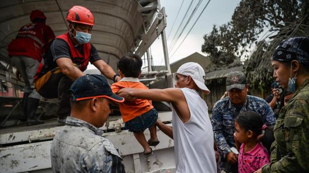 Rescuer workers load children onto a truck as they evacuate them to a safe place in Talisay town, Batangas province. Police said more than 13,000 villagers had moved to evacuation centres in the hard-hit province of Batangas and nearby Cavite province, but officials expect the number to swell with hundreds of thousands more being brought out of harm’s way. (Ted Aljibe/AFP) Rescuer workers load children onto a truck as they evacuate them to a safe place in Talisay town, Batangas province. Police said more than 13,000 villagers had moved to evacuation centres in the hard-hit province of Batangas and nearby Cavite province, but officials expect the number to swell with hundreds of thousands more being brought out of harm’s way. (Ted Aljibe/AFP)