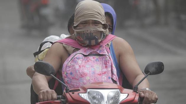 A man rides his motorcycle while covering his face along an ash-covered road as they evacuate the area in Lemery. Taal had been restive for months until it suddenly rumbled back to life Sunday, blasting steam, ash and pebbles up to 10 to 15 kilometre into the sky, according to the Philippine Institute of Volcanology and Seismology. The lava spurting from the volcano’s vents Monday was falling into the lake surrounding the crater. (Aaron Favila/AP) A man rides his motorcycle while covering his face along an ash-covered road as they evacuate the area in Lemery. Taal had been restive for months until it suddenly rumbled back to life Sunday, blasting steam, ash and pebbles up to 10 to 15 kilometre into the sky, according to the Philippine Institute of Volcanology and Seismology. The lava spurting from the volcano’s vents Monday was falling into the lake surrounding the crater. (Aaron Favila/AP)