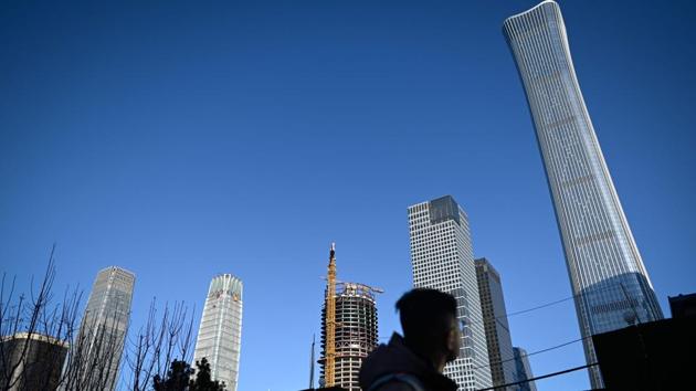 A man looks at buildings at a Central Business District(CBD) in Beijing. The Trump administration called off new tariffs on Chinese-made goods such as electronics that were to take effect last month. It also halved those imposed on September 1 on $120 billion worth of products. (Wang Zhao / AFP) A man looks at buildings at a Central Business District(CBD) in Beijing. The Trump administration called off new tariffs on Chinese-made goods such as electronics that were to take effect last month. It also halved those imposed on September 1 on $120 billion worth of products. (Wang Zhao / AFP)