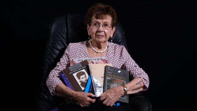 Holocaust survivor Batcheva Dagan, whose entire family was killed, poses with books she authored, during a photo session at her home in the Israeli town of Holon, south of Tel Aviv. Born in Poland in 1925, she became a pioneer in the field of Holocaust education, and has dedicated her life to teaching. Originally from Europe, the survivors spent part of their childhood in the notorious extermination camp before moving after World War II to Israel. (Menahem Kahana / AFP) 