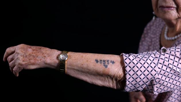 Dagan shows her arm with the Auschwitz prison number 45554. An educator and psychologist, she has written six books about the Holocaust of which five are for children. “I don’t only recount the horror of the Holocaust, but also wonderful things like helping each other, the capacity to share a piece of bread, the friendship... We remained human beings,” said Dagan. (Menahem Kahana / AFP) 