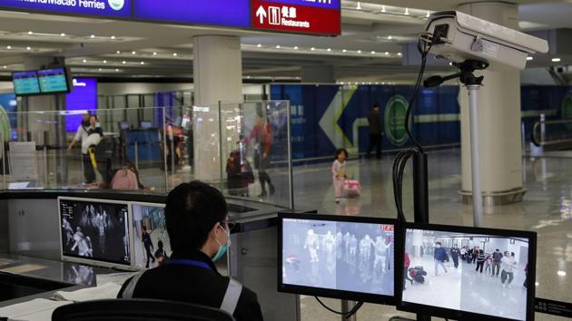 A health surveillance officer monitors passengers arriving at the Hong Kong International airport in Hong Kong.(AP Photo)