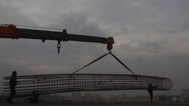 Workers carry a metal frame as clouds hover over the city on a cold winter morning. (Yogendra Kumar / Hindustan Times) Workers carry a metal frame as clouds hover over the city on a cold winter morning. (Yogendra Kumar / Hindustan Times)
