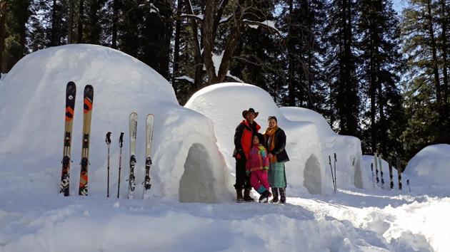Tourist click pose for picture with India’s first Igloo hotel in Manali, on Wednesday.(ANI PHOTO)