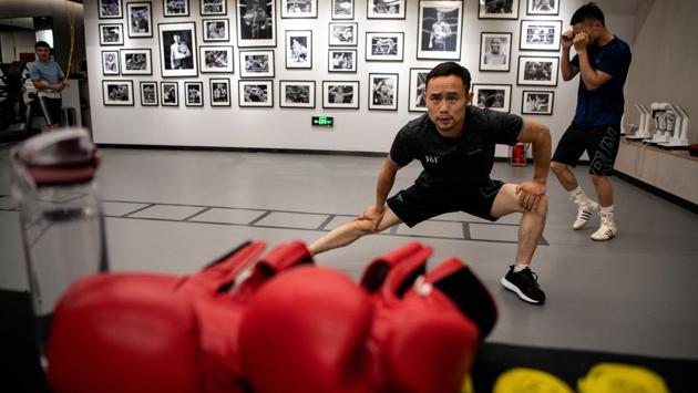 Boxer and food delivery man, Zhang Fangyong, warming up at a boxing gym in Beijing. Unlike his idol Floyd “Money” Mayweather who could earn hundreds of millions of dollars from a bout, Zhang sometimes fights for nothing and supports himself by making deliveries on his motorbike. (Noel Celis / AFP) Boxer and food delivery man, Zhang Fangyong, warming up at a boxing gym in Beijing. Unlike his idol Floyd “Money” Mayweather who could earn hundreds of millions of dollars from a bout, Zhang sometimes fights for nothing and supports himself by making deliveries on his motorbike. (Noel Celis / AFP)