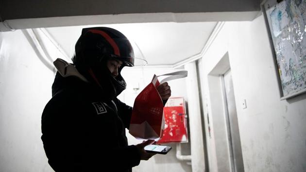 Zhang checks a tag on the food package before delivering it to a customer in Beijing. His job as a delivery driver, first in the city of Kunming and now in the capital Beijing, comes with its own challenges. (Noel Celis / AFP) Zhang checks a tag on the food package before delivering it to a customer in Beijing. His job as a delivery driver, first in the city of Kunming and now in the capital Beijing, comes with its own challenges. (Noel Celis / AFP)