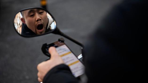 Zhang yawns as he checks his phone for orders from customers. Zhang’s determination was forged during a tough childhood. The nearest town was a hike down a mountain from his home, where his mother raised pigs and chickens and sold eggs to keep the family afloat. His father worked away from the village. (Noel Celis / AFP) Zhang yawns as he checks his phone for orders from customers. Zhang’s determination was forged during a tough childhood. The nearest town was a hike down a mountain from his home, where his mother raised pigs and chickens and sold eggs to keep the family afloat. His father worked away from the village. (Noel Celis / AFP)